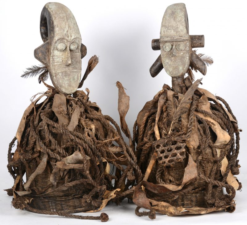 Een paar gevlochten manden, bovenaan versierd met een houten hoofd met koperbeslag en versierd met touwen en leer. Afrikaans leer.