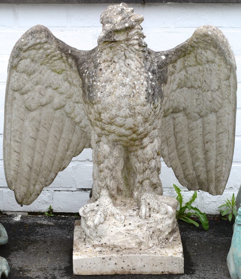 Een stenen tuinbeeld in de vorm van een adelaar.