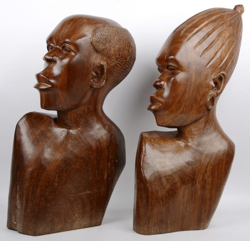 Een vrouwen- en mannenbuste van gesculpteerd hout. Afrikaans werk. Eén oor beschadigd.