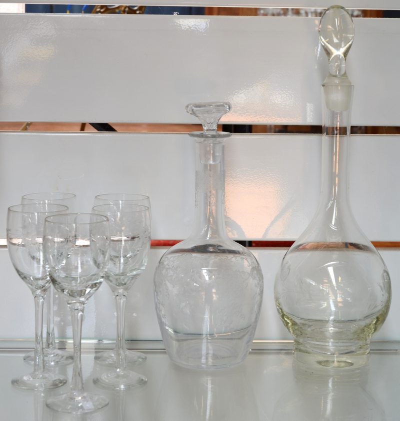 Een lot glaswerk, bestaande uit twee verschillende glazen karaffen en vijf glazen, allen met gegraveerde decors.