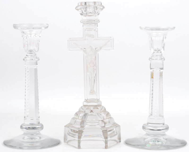 Twee kristallen kandelaars gemerkt Val Saint-Lambert en een kristallen kandelaar in de vorm van een kruisbeeld.