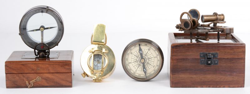 Een miniatuur sextant in een houten kistje. Een replica van een scheepskompas in een houten kistje. Een klein messingen scheepskompas en een ander kompas in een ronde doos met schroefdeksel met opschrift “Makers to the Queen, London 1953”.