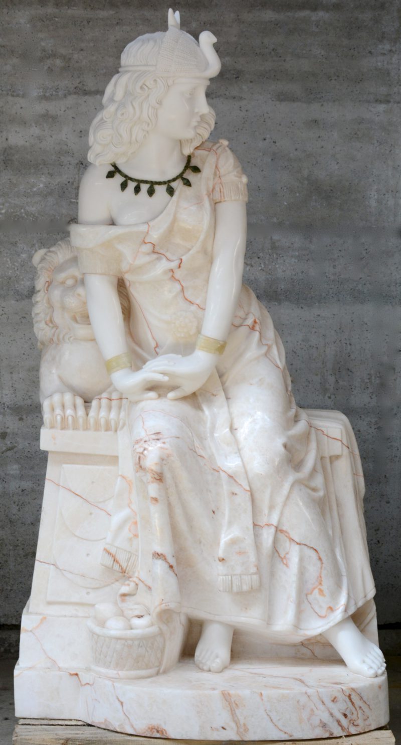 “Jonge vrouw bij een tempelleeuw”. Een beeld van roodgeaderd marmer met hoofd en armen van wit marmer, armbanden van onyx en halsketting van malachiet.