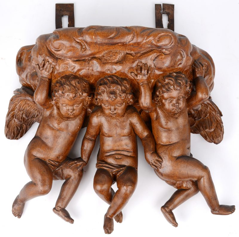 Een hangconsole van gebeeldhouwd hout, gedragen door drie engeltjes.