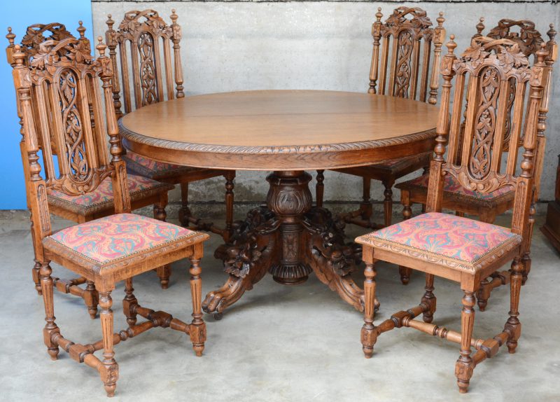 Een eikenhouten tafel in renaissancestijl met leeuwenpoten en met zes bijpassende stoelen.