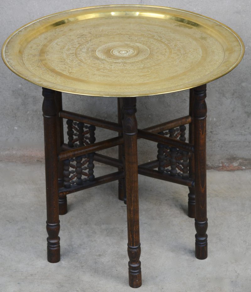 Een Arabisch tafeltje met inplooibare poot en een messingen blad.