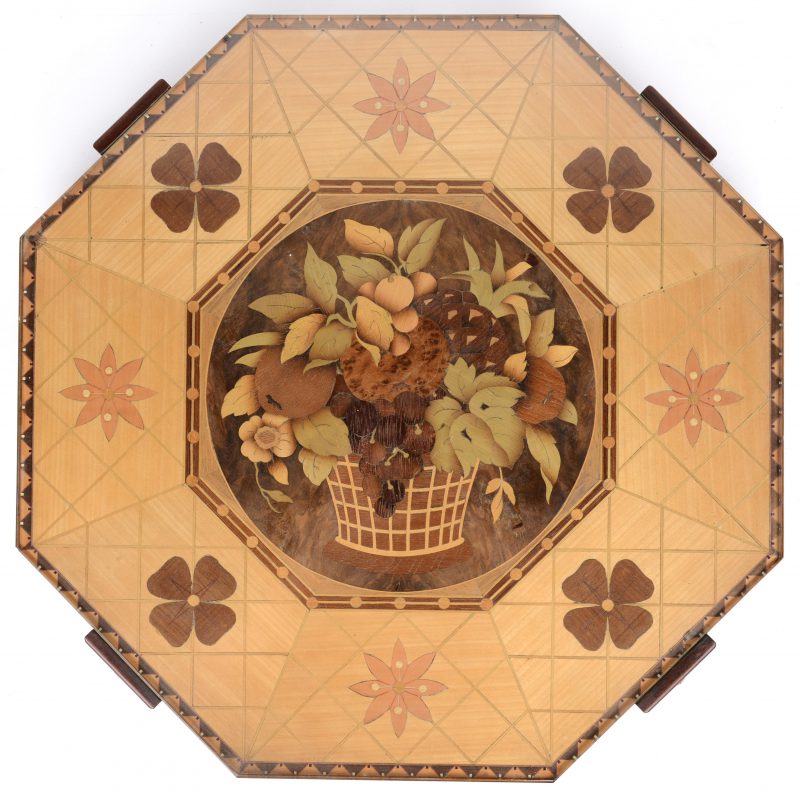 Een achthoekig roterend dienblad, versierd met een fruitmand en bloemen in marquetterie en onder een glazen blad.