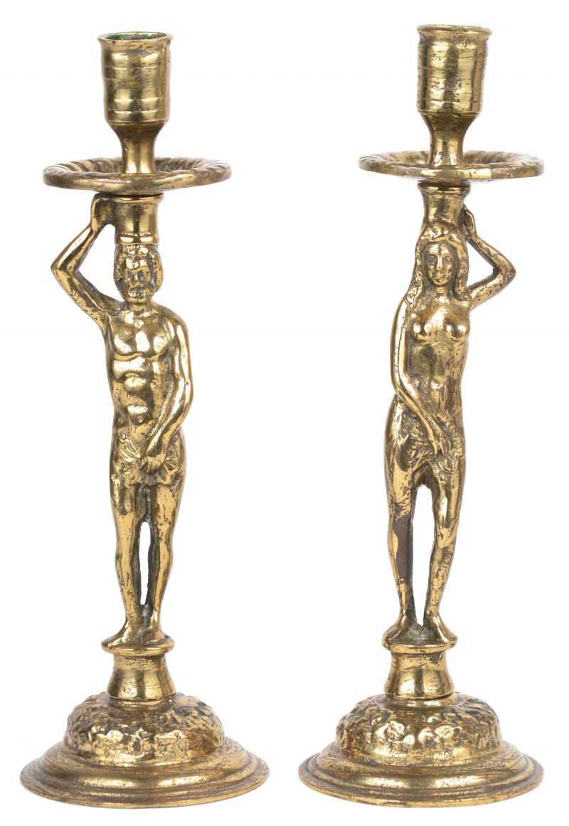 Een paar bronzen kandelaars met een voorstelling van Adam en Eva.