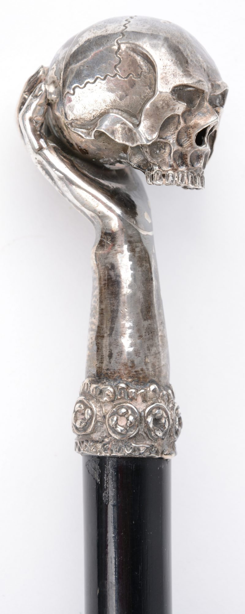 Een wandelstok met zilveren handgreep in de vorm van een hand met een schedel.