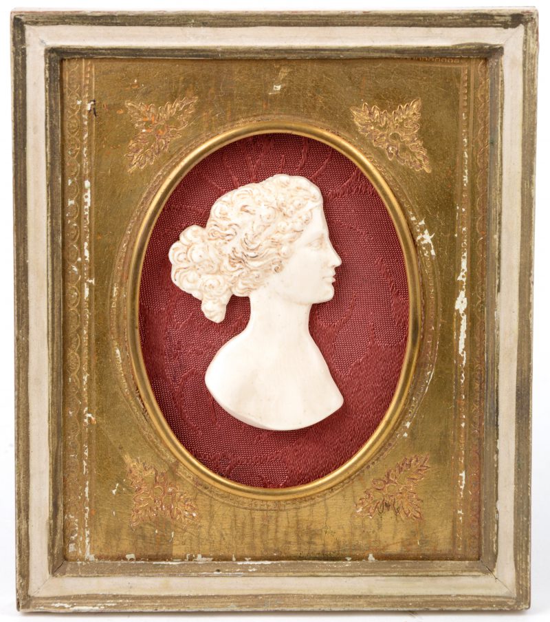 Een miniatuur damesprofiel van gesculpteerd ivoor in kadertje.