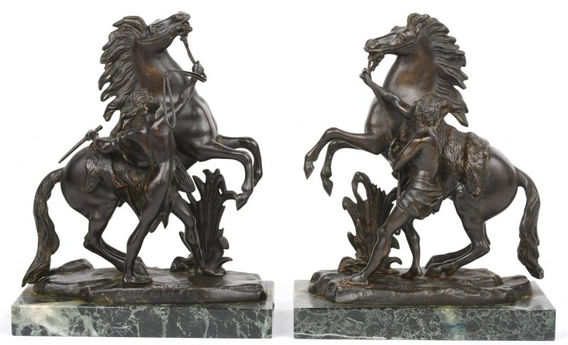 “Les chevaux de Marly”. Twee bronzen groepjes op groen marmeren voetstuk. Gesigneerd.
