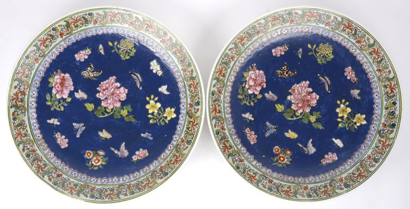 Een paar schotels van Chinees porselein met een decor van pioenen op blauwe fond. Onderaan gemerkt.