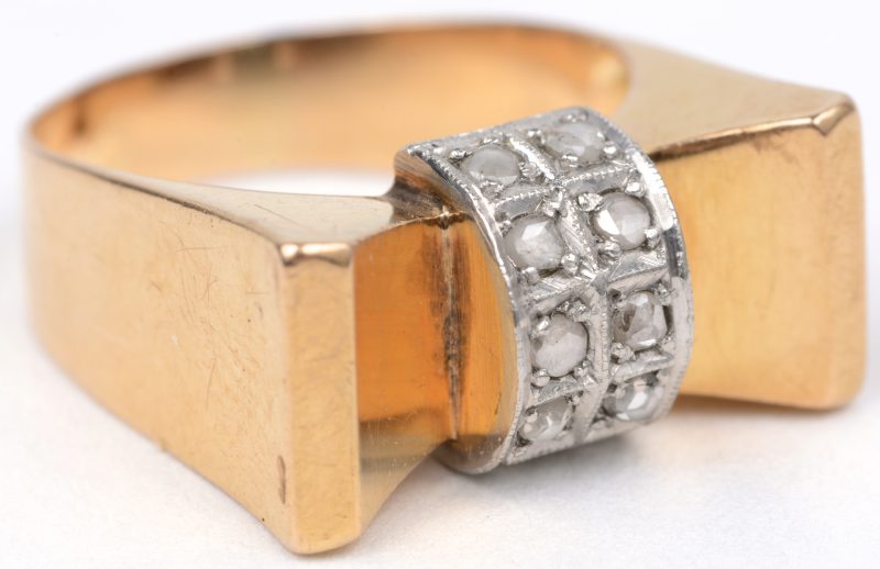 Een 18 karaats wit en geel gouden strikvormige ring bezet met diamanten oude slijp met een gezamenlijk gewicht van ± 0,20 ct.