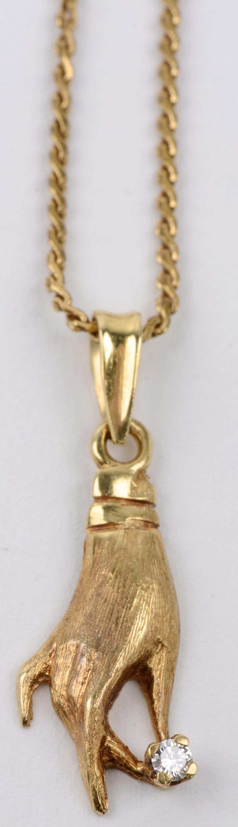 Een 18 karaats geel gouden ketting met een hand als hanger van 18 karaats geel goud.