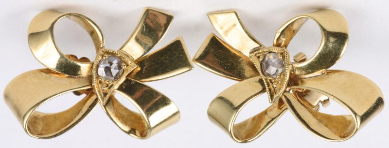 Een paar 18 karaats geel gouden oorbellen bezet met twee diamanten oude slijp van ± 0,10 ct.