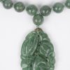 Een parelhalssnoer van jade met hanger van jade en met zilveren slot.
