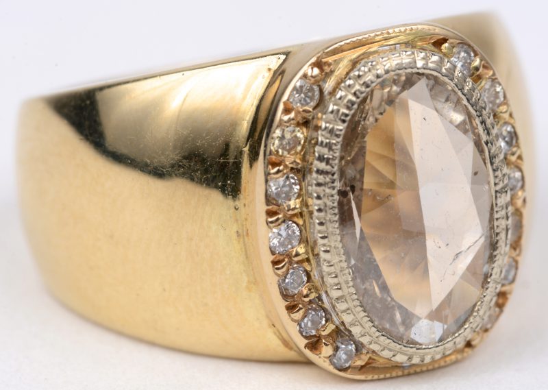 Een 18 karaats geel gouden ring bezet met diamanten met een gezamenlijk gewicht van ± 0,30 ct. en een champagne kleurige diamant van ± 2,50 ct.