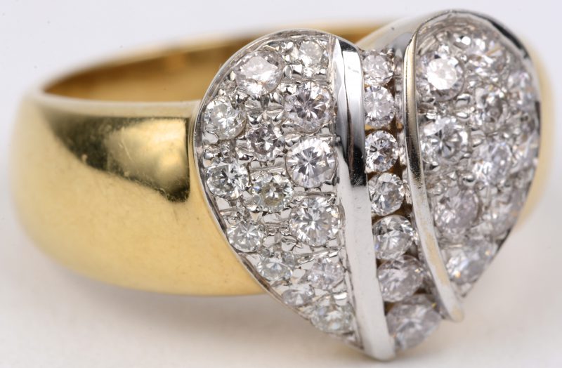Een 18 karaats wit en geel gouden ring bezet met diamanten in hartvorm gezet met een gezamenlijk gewicht van ± 1 ct.