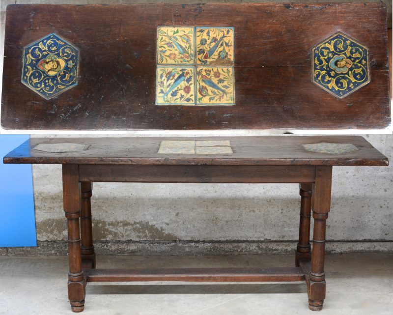Een sobere eikenhouten tafel. Het blad versierd met Perzische tegels, waarbij twee zeshoekige met personages en vier vierkante met vissen. Omstreeks 1800.
