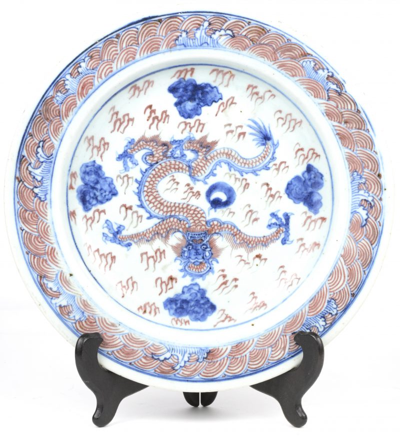 Een schotel van Chinees porselein met een draak in het decor. Apocrief gemerkt.