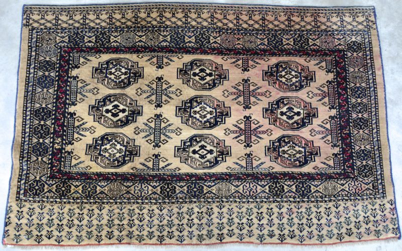 Een antiek handgeknoopt Oosters karpetje van wol. Slijtage.