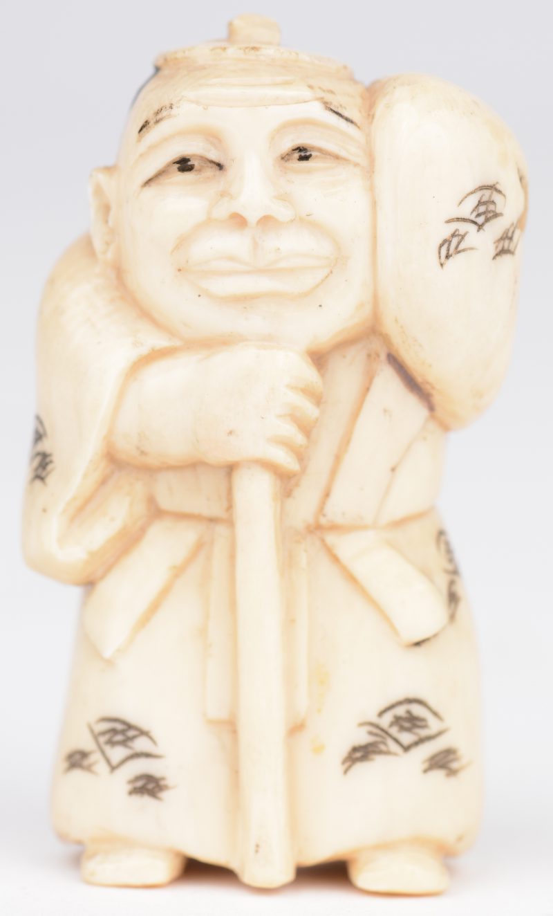 “Man met staf”. Netsuké van gebeeldhouwd ivoor. Japan, eerste kwart XXste eeuw. Onderaan gemerkt.