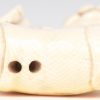 “Tijgerkat op een kussen”. Netsuké van gebeeldhouwd ivoor. Japan, eerste kwart XXste eeuw. Onderaan gemerkt.