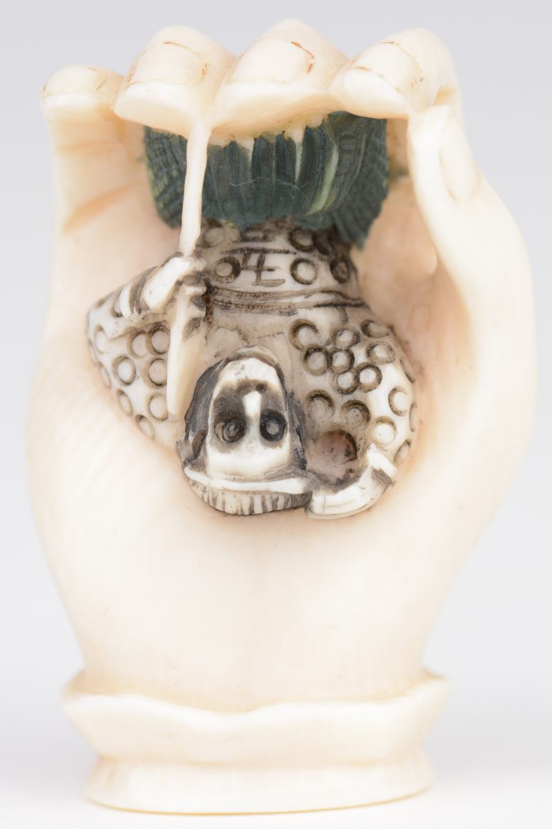“Hand met aapje”. Netsuké van gebeeldhouwd ivoor. Japan, eerste kwart XXste eeuw. Onderaan gemerkt.