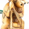 Inro versierd met karpers in reliëf en netsuké van gebeeldhouwd ivoor met voorstelling van een visser met uitpuilende ogen. Japan, eerste kwart XXste eeuw. Onderaan gemerkt.