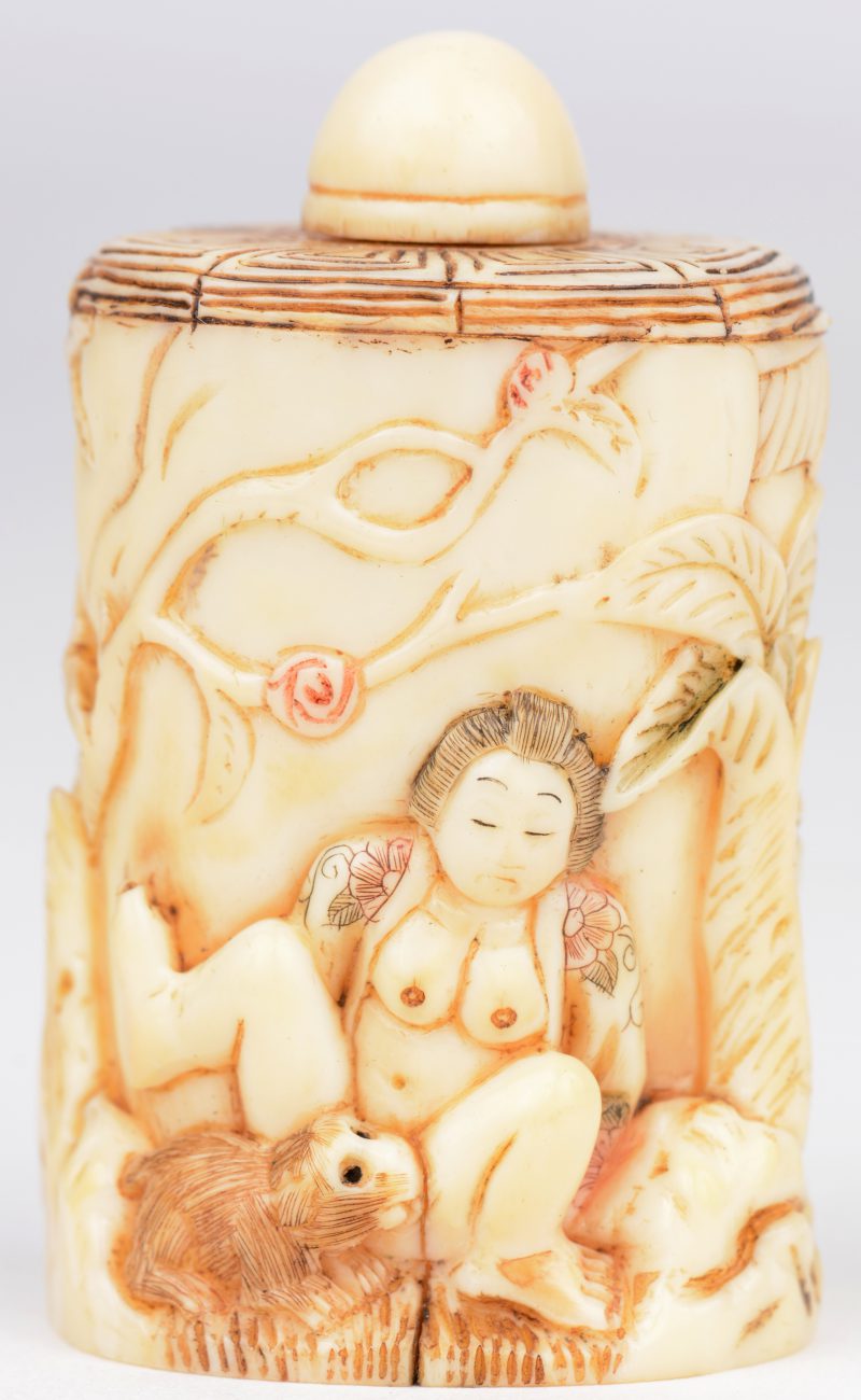 Snuffbottle van gebeeldhouwd ivoor. Erotische voorstelling in reliëf van een vrouw die zich laat plezieren door een knaagdier in een tuin. Japans werk, eerste kwart XXste eeuw. Onderaan gemerkt.