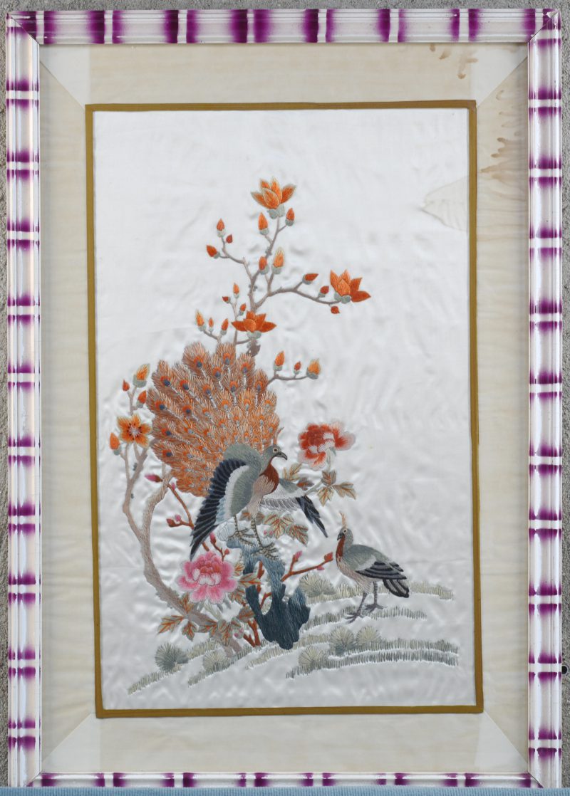 Een Chinees borduurwerk op zijde met pauwen bij een bloesemende struik. Medio XXe eeuw.