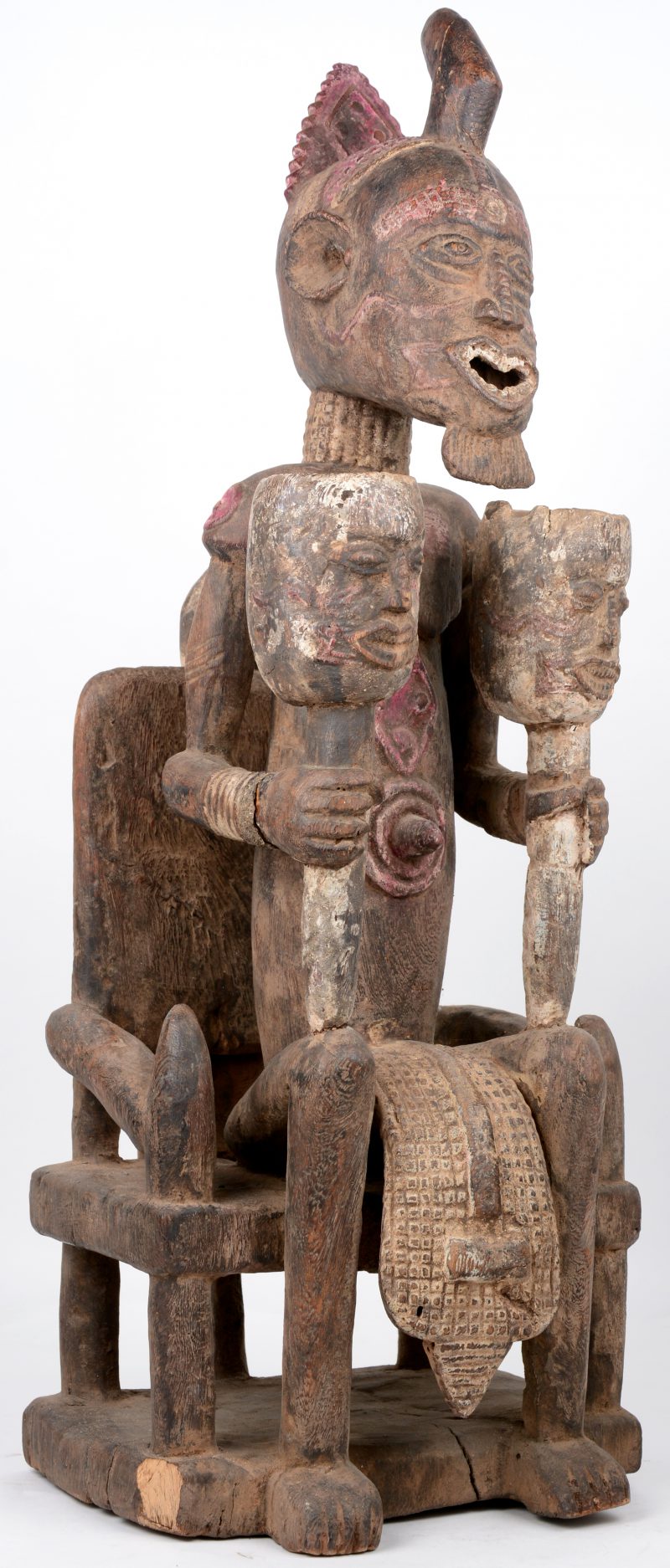 Een zittende voorouder van gebeeldhouwd hout. Met attributen van een hoogwaardigheidsbekleder. Kleine letsels en herstellingen. Stroomgebied van de Benue-rivier (Nigeria of Congo).