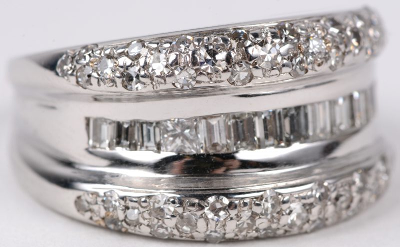 Een 18 karaats wit gouden ring bezet met diamanten en baguetten en één princes cut met een gezamenlijk gewicht van ± 1 ct.