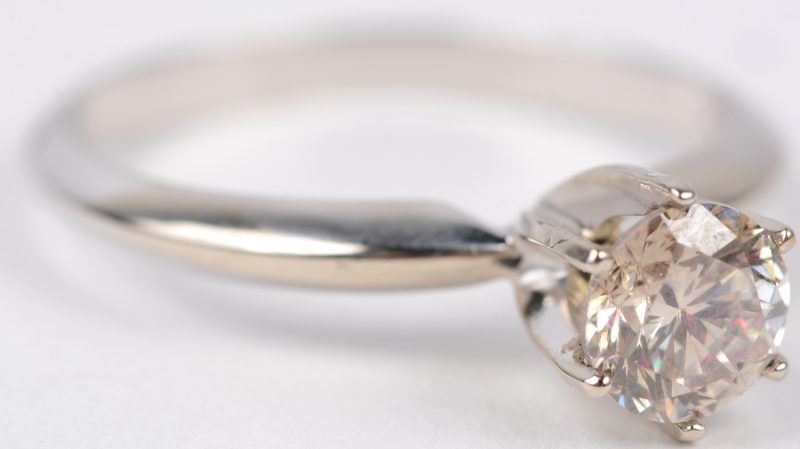 Een 14 karaats wit gouden ring bezet met een centrale fancy diamant van ± 0,71 ct. SI1.