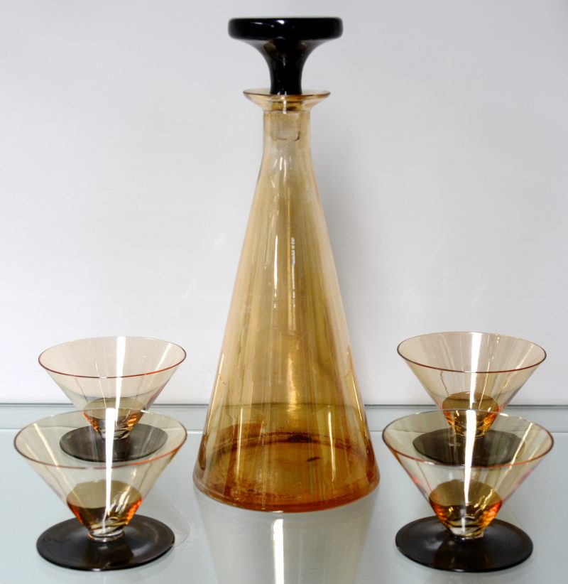 Een karaf van rookbruin en zwart glas met vier bijpassende glaasjes.