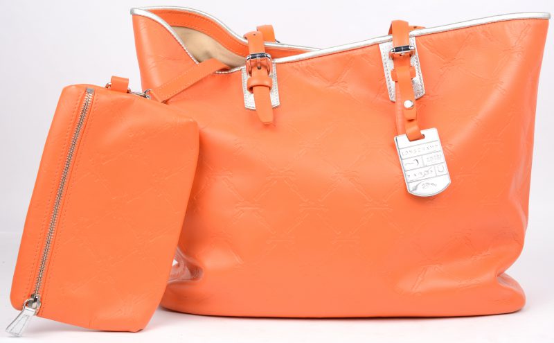 Een handtas en een pochette van oranje leder. Met stofzak en in originele doos.