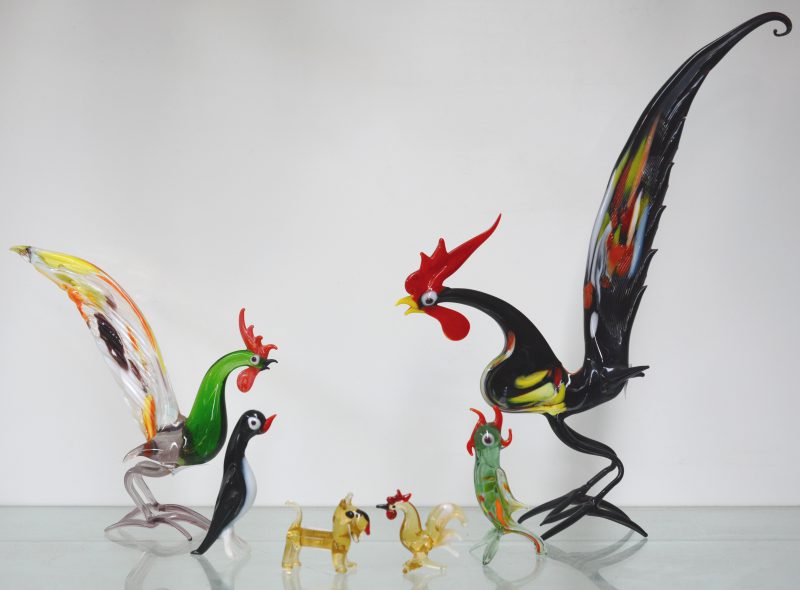 Een lot diertjes van meerkleurig Muranoglas, bestaande uit drie hanen, een pinguin, een papegaai en een hondje.