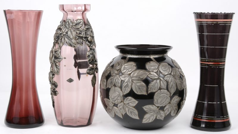 Een lot Booms glas, bestaande uit een bolle ronde en een langwerpige vaas met gedreven tinnen bloemendecor en twee holle langwerpige vazen, waarbij een mauve en een zwarte.