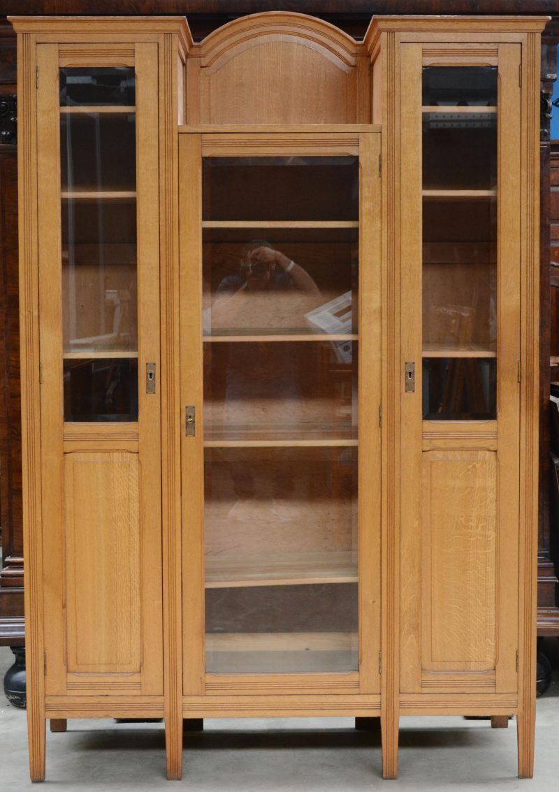 Een eikenhouten servieskast met twee smalle gevitreerde deuren naast een breder exemplaar.