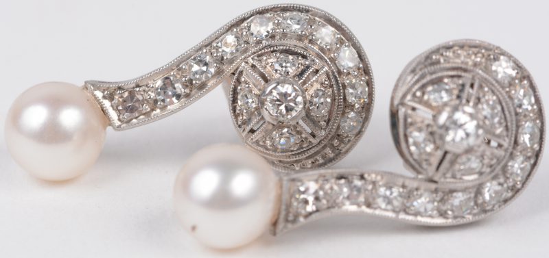 Een paar 18 karaats wit gouden art deco oorbellen bezet met diamanten met een gezamenlijk gewicht van ± 0,80 ct. en twee parels.