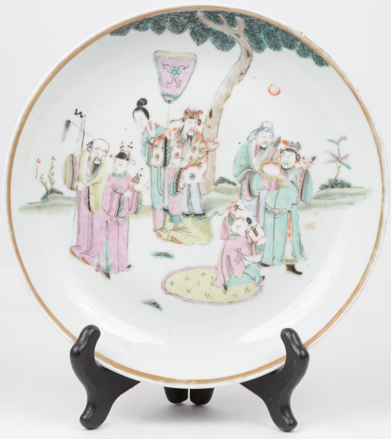 Een diep bord van Chinees porselein met personages in het decor en met vergulde rand. Onderaan gemerkt. XIXe eeuw.