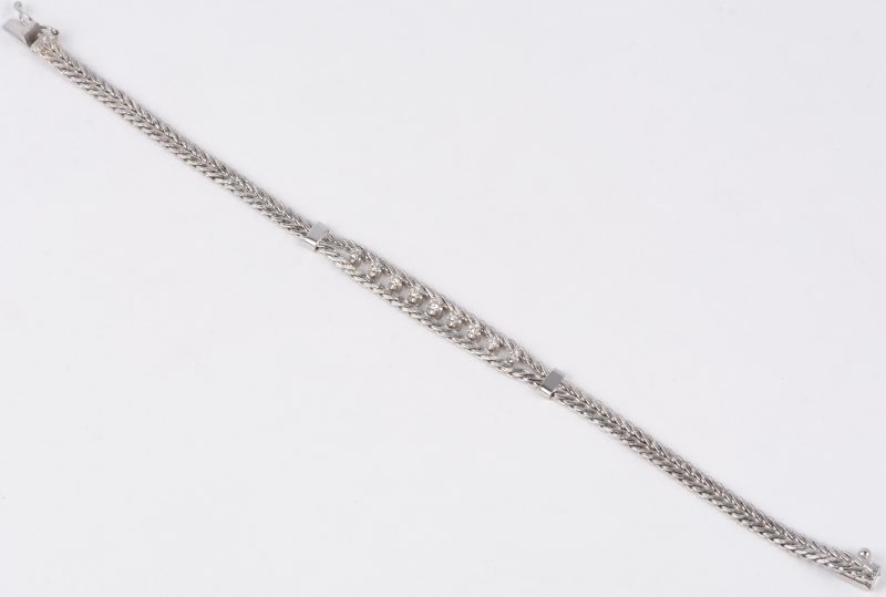 Een 18 karaats wit gouden geweven armband bezet met briljanten met een gezamenlijk gewicht van ± 0,20 ct.