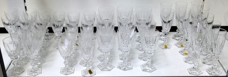 Een glasservies van geslepen kleurloos kristal, bestaande uit champagnefluiten, witte- en rodewijnglazen en waterglazen. Compleet voor twaalf personen.
