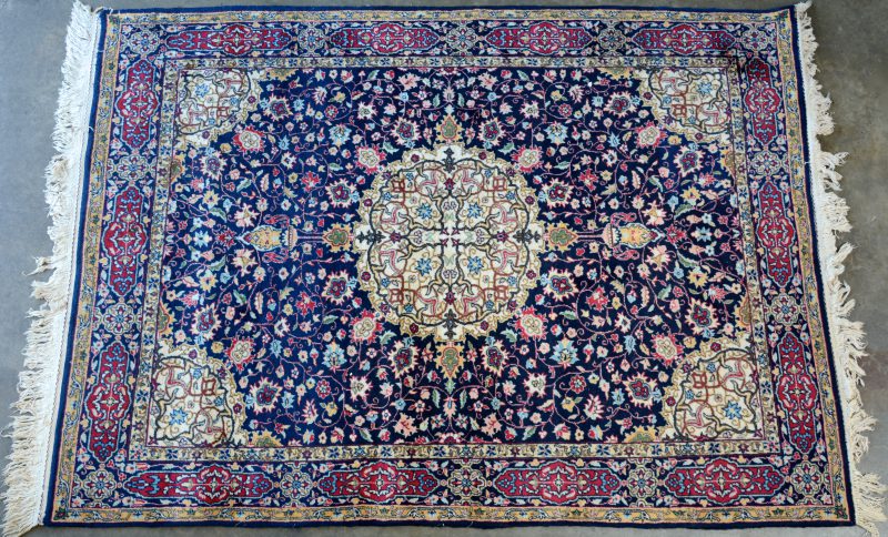 Een handgeknoopt Perzisch wollen karpet met een centraal motief.