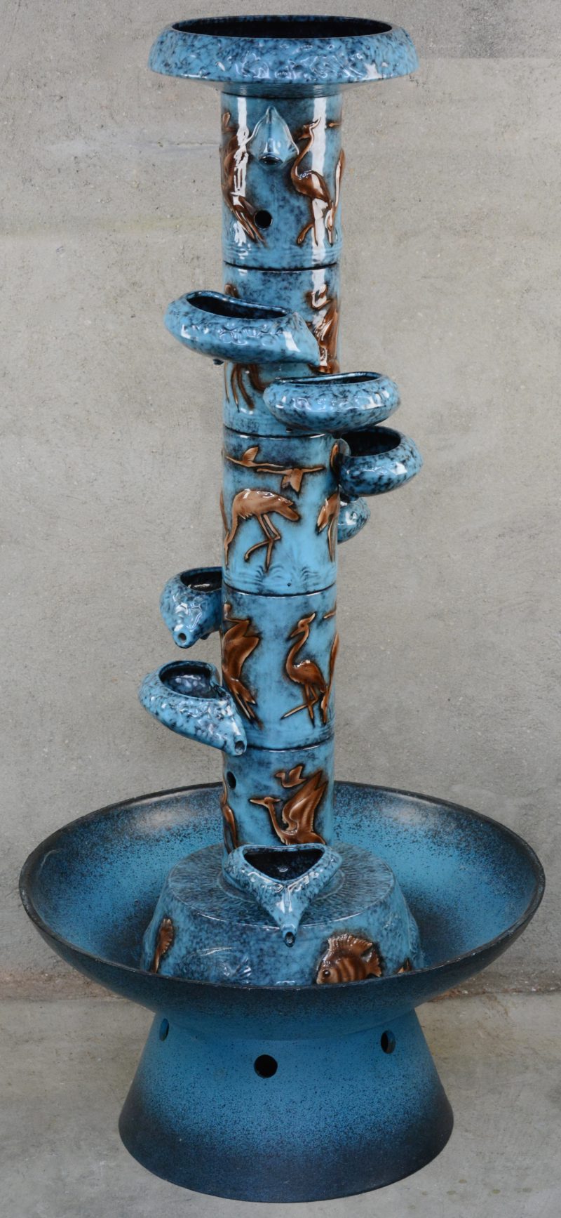 Een fontein van blauw geglazuurd aardewerk, opgebouwd uit verschillende delen. Jaren ‘70.