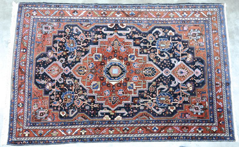 Een antiek handgeknoopt Perzisch karpetje van wol.