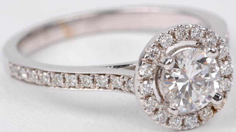Een 18 karaats wit gouden ring bezet met diamanten met een gezamenlijk gewicht van ± 0,30 ct. en een centrale loepzuivere diamant van ± 0,61 ct. Color D. Met certificaat.