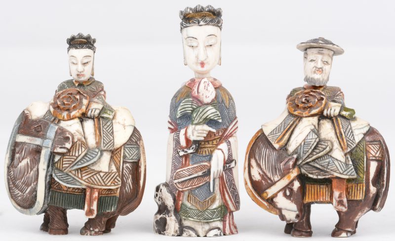 Drie snuffbottles van gebeeldhouwd en gepolychromeerd ivoor. De hoofdjes doen dienst als stop. In de vorm van een Guanyin, een keizer op een paard en een keizerin op een kameel. Chinees werk, begin XXste eeuw.