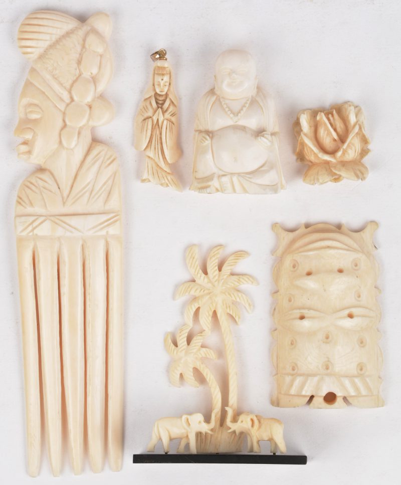 Een gevarieerd lot Afrikaans en Chinees ivoor: een kam, een beeldje met palmbomen en olifanten, een maskertje, een hanger in de vorm van een roos en één in de vorm van Guanyin en een Happy Buddha. Eerste helft van de XXste eeuw.