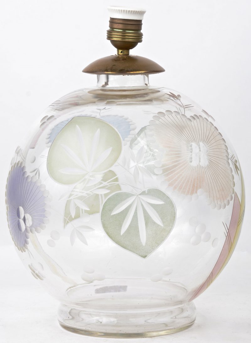 Een glazen lampvoet met een geslpen bladermdecor.